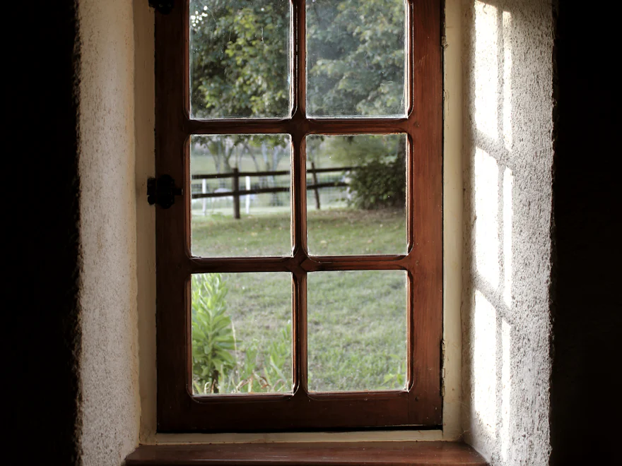 A cottage window looking out on a field